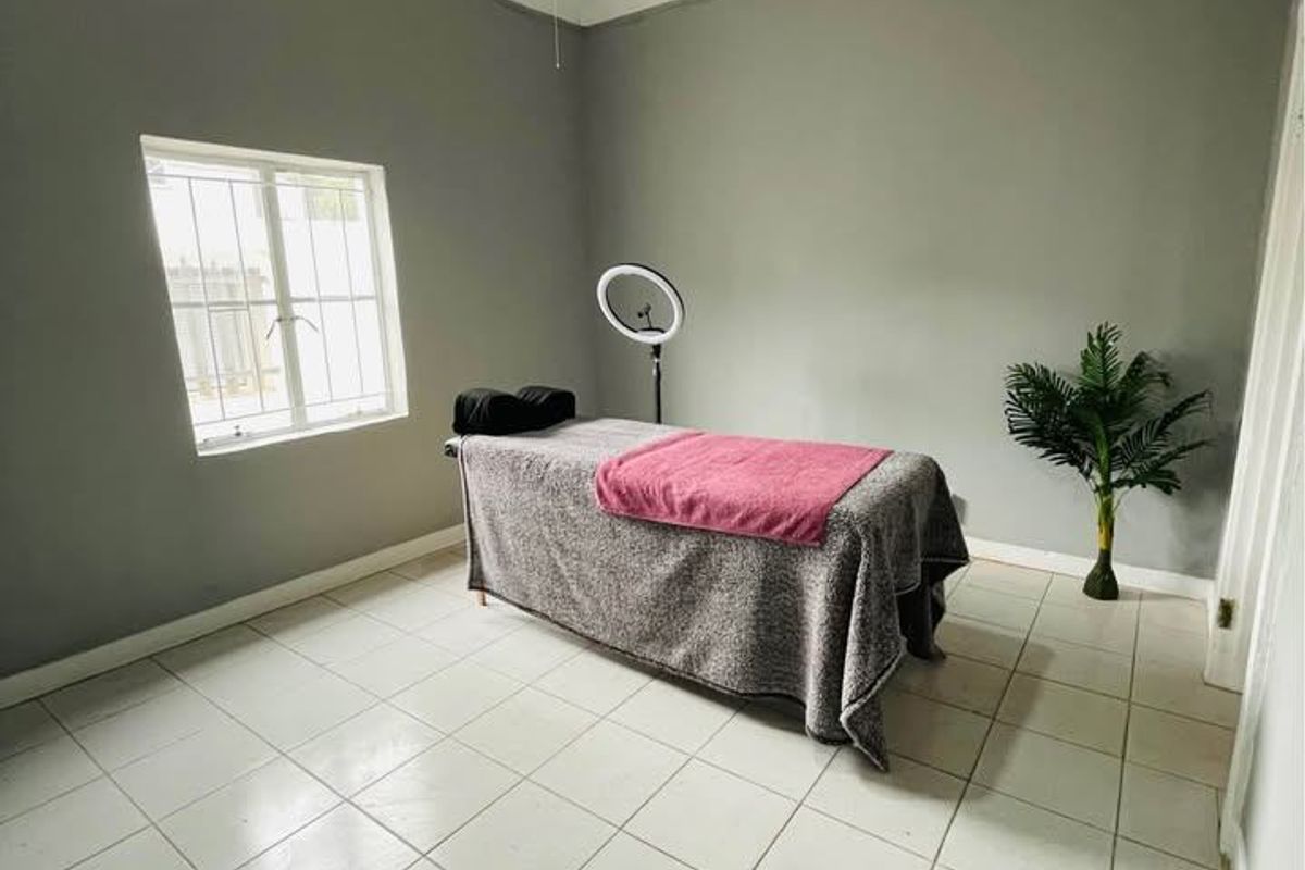 A bedroom featuring decorative ceiling tiles, a ceiling fan, tiled flooring, and a window with security bars.
