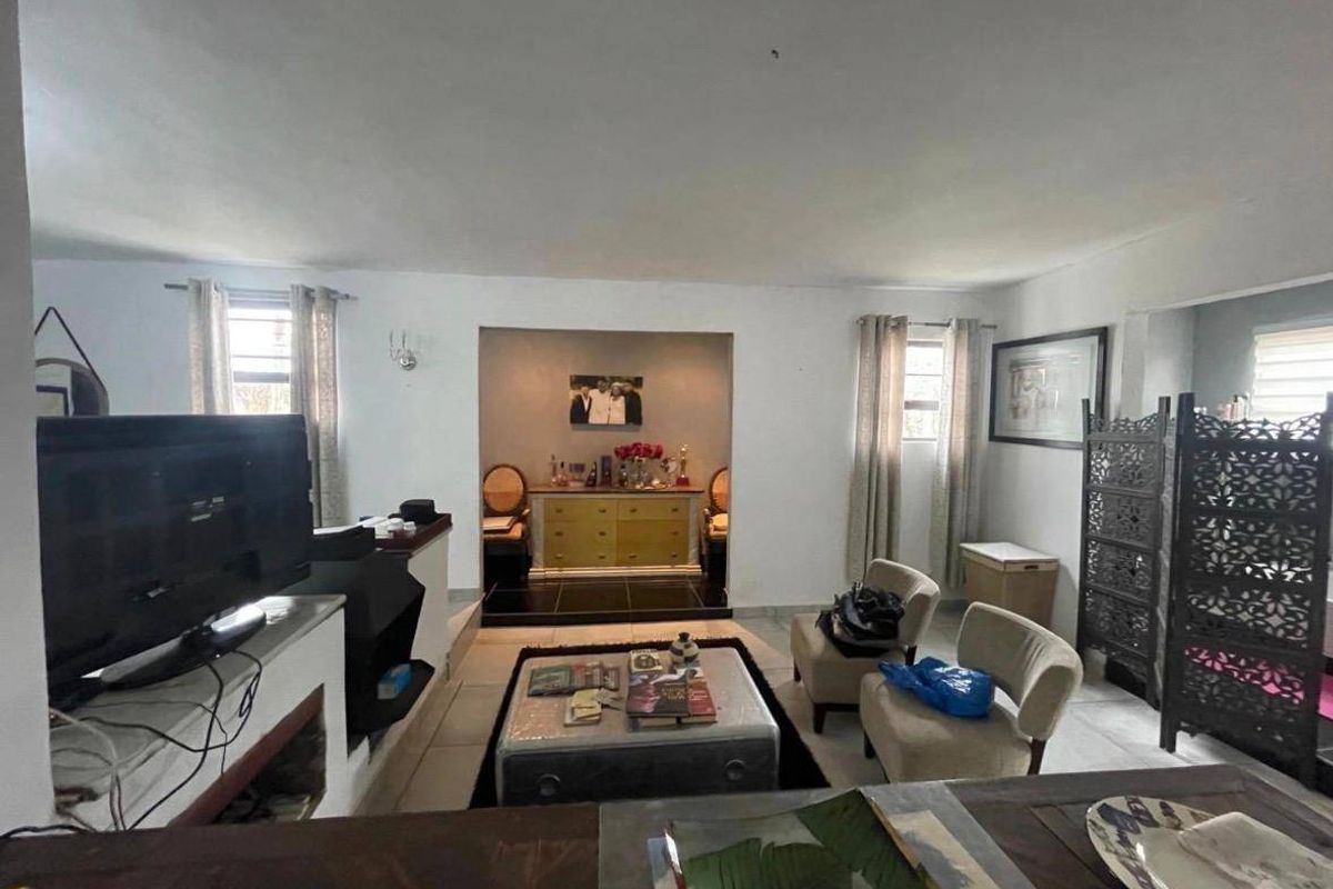 A spacious living room featuring tiled flooring and a central recessed alcove, offering a versatile layout for comfortable family living.