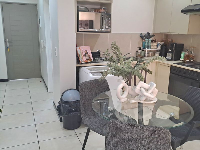 A functional kitchen featuring built-in cabinetry, integrated oven and hob, extractor fan, and tiled flooring, providing a practical cooking and dining space.