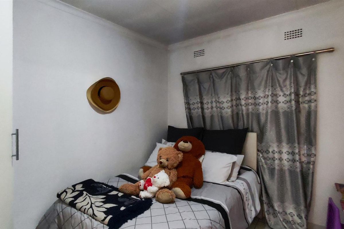 A compact bedroom featuring a built-in cupboard, curtain rail, and ventilation bricks, providing a functional space for rest.