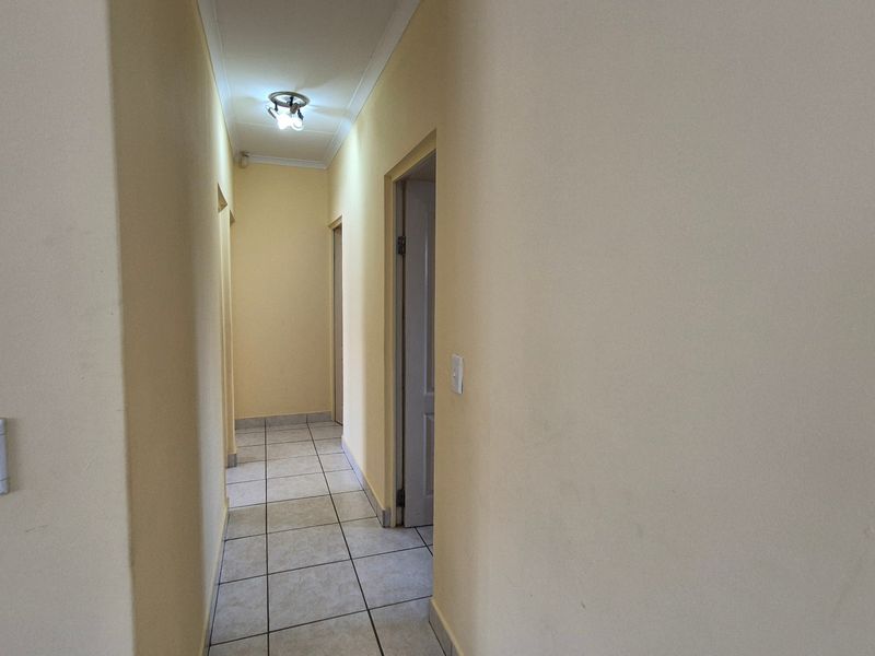 A functional hallway featuring tiled flooring and access to multiple rooms, providing a neutral transition space within the home.