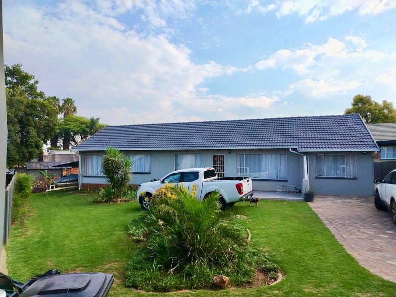 Front view of a single-story house featuring a tiled roof, paved driveway, and a well-maintained front garden.