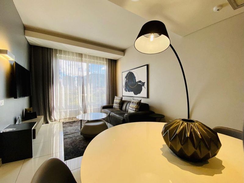 Modern open-plan living and dining area featuring sleek tiled flooring, recessed lighting, and large sliding glass doors providing ample natural light.