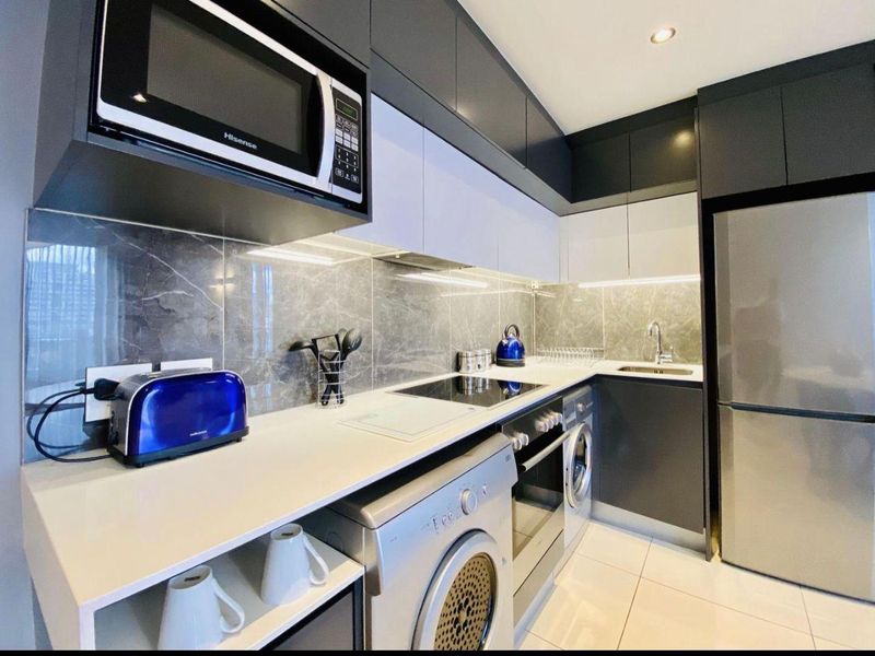 Modern kitchen featuring sleek two-tone cabinetry, stone countertops, marble-look splashback, integrated appliances, and high-quality finishes throughout.