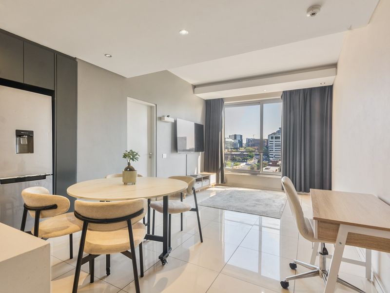 Modern open-plan living area featuring sleek cabinetry, polished tiled floors, and large windows with expansive city views.
