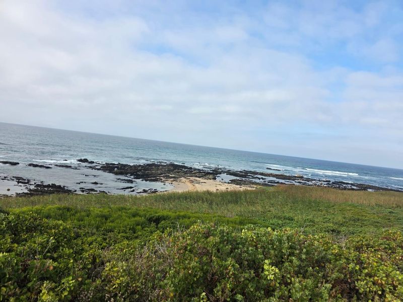 A scenic view of the coastal landscape featuring a rocky shoreline and ocean frontage, highlighting the natural beauty of the vacant land.