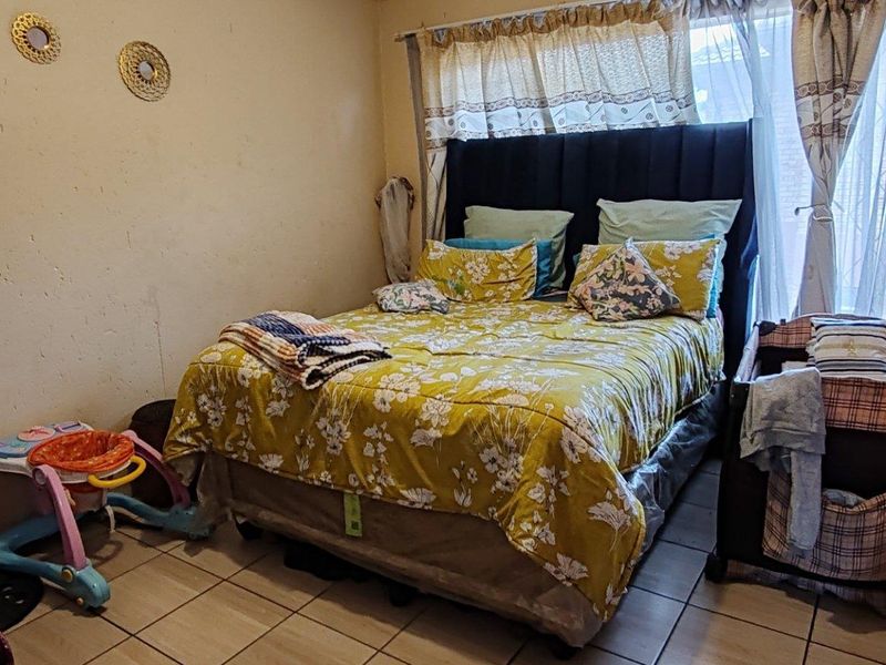 A bedroom featuring tiled flooring and a built-in wardrobe, requiring cosmetic updates to the wall finishes.