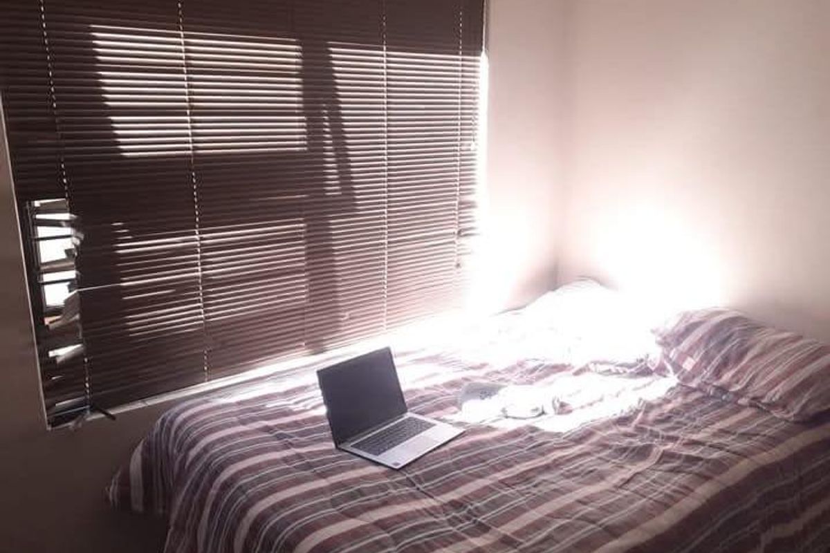 A bedroom featuring fitted venetian blinds, providing a functional space with natural light.
