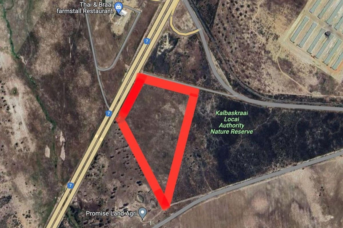 Aerial view of a vacant residential plot highlighted in red, situated near the N7 highway and local nature reserve.