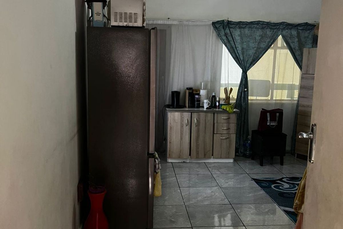 A functional kitchen area featuring tiled flooring and built-in cabinetry, providing a practical space for meal preparation and storage.