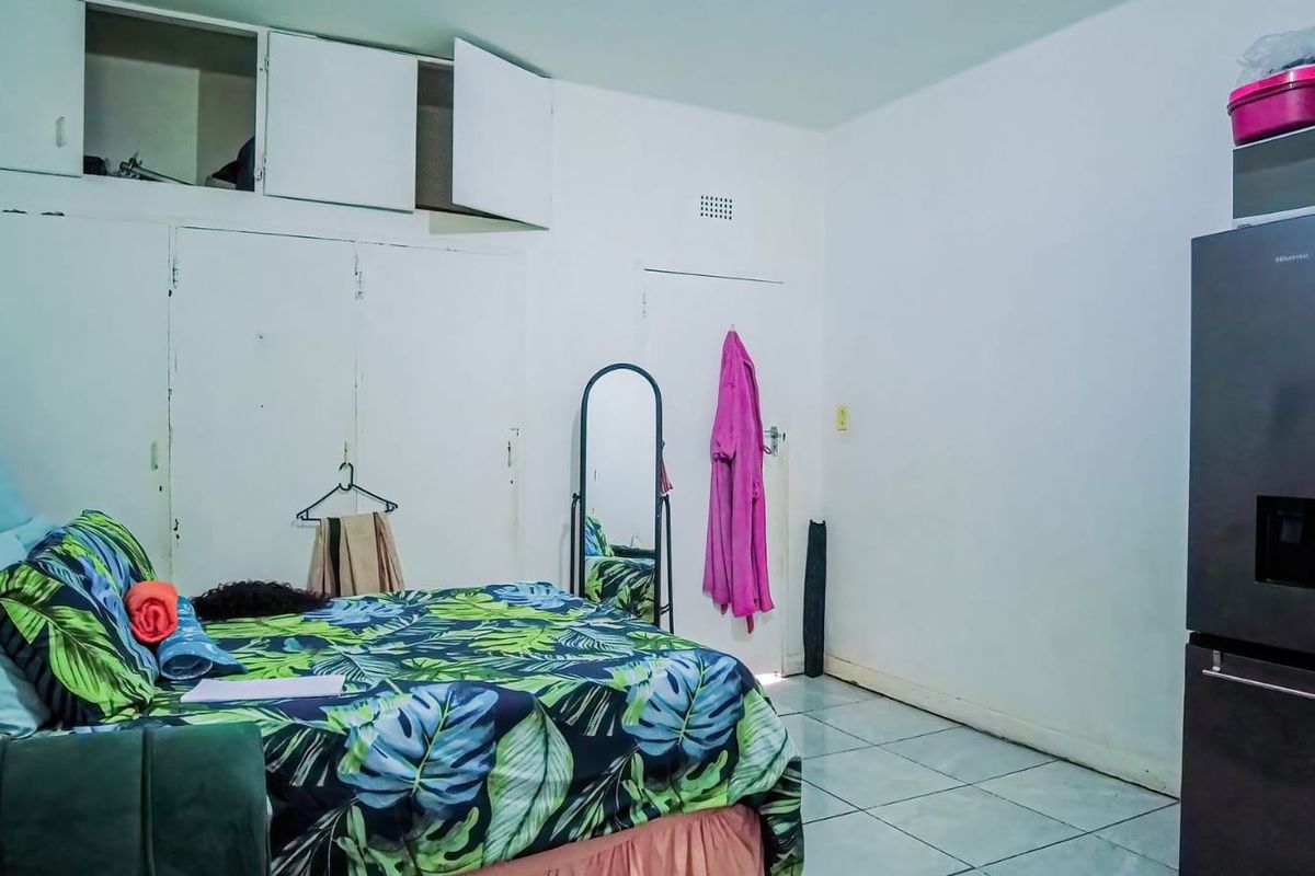 A bedroom featuring tiled flooring and built-in storage cupboards with overhead compartments.
