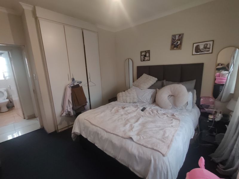 A bedroom featuring built-in cupboards and direct access to an en-suite bathroom, providing a functional layout for a primary or guest suite.