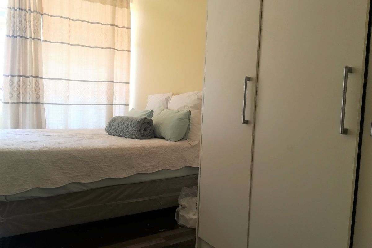A bedroom featuring a built-in wardrobe and natural light from a window.