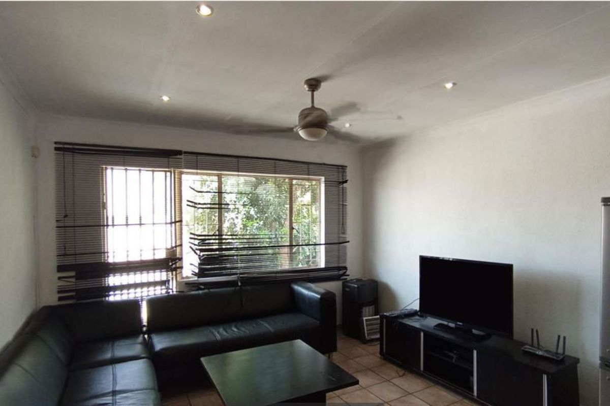 A living room featuring tiled flooring, recessed downlighting, a ceiling fan, and security bars on the windows.
