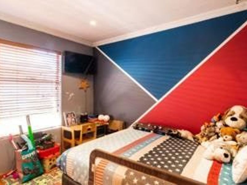 A bedroom featuring a geometric accent wall, venetian blinds, and recessed ceiling lighting.