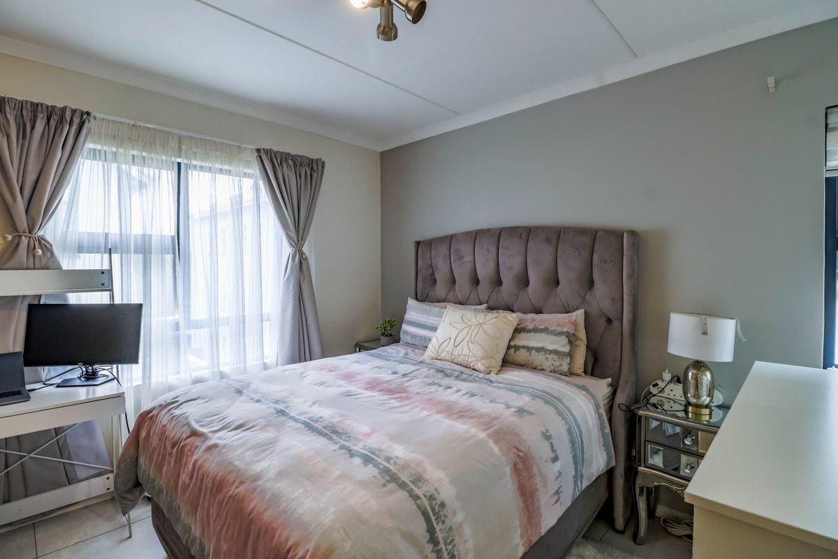 A well-maintained bedroom featuring tiled flooring and neutral wall tones, providing a comfortable and functional living space.
