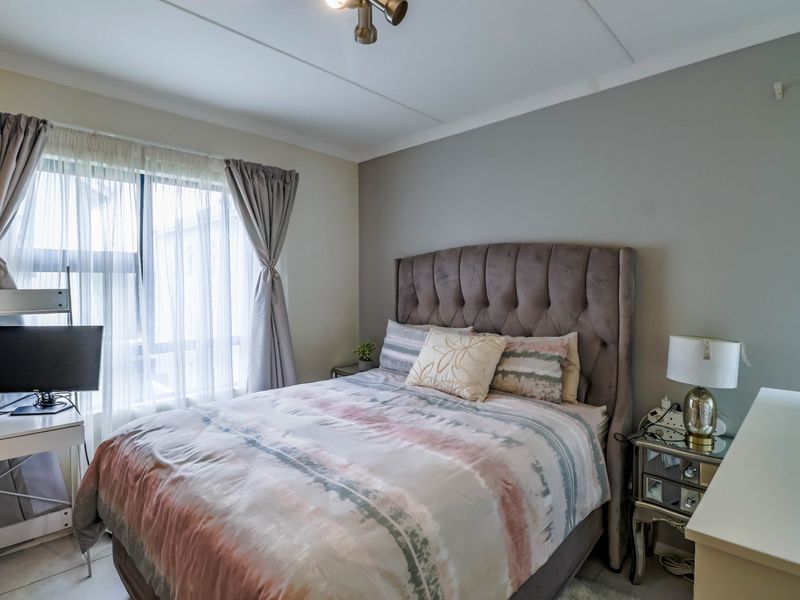 A well-maintained bedroom featuring tiled flooring and neutral wall tones, providing a comfortable and functional living space.