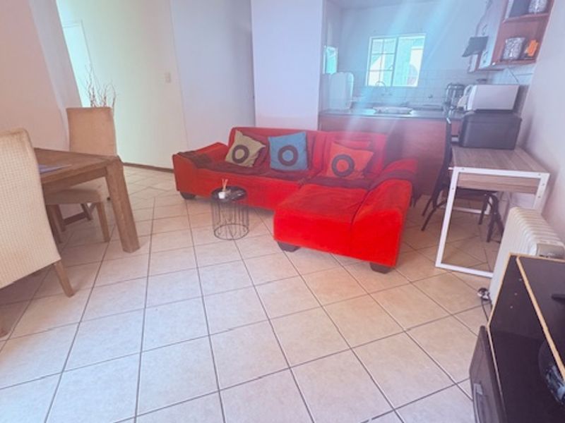 Open plan living and dining area featuring tiled flooring and a view through to the kitchen space.