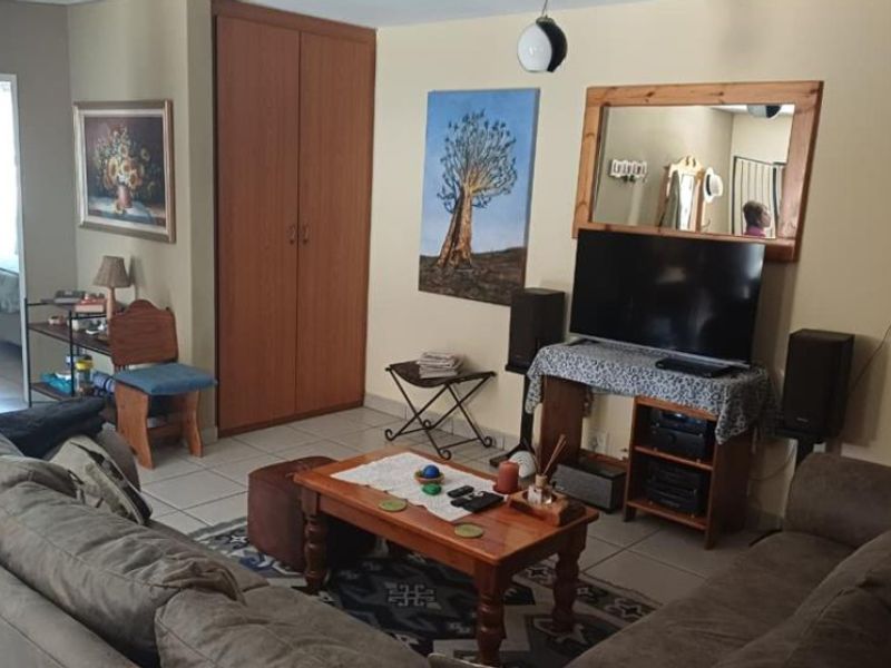 A living room featuring tiled flooring and a built-in cupboard, providing a functional and comfortable space for relaxation.
