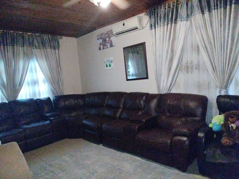 A living room featuring a timber-paneled ceiling and a wall-mounted split-system air conditioning unit.
