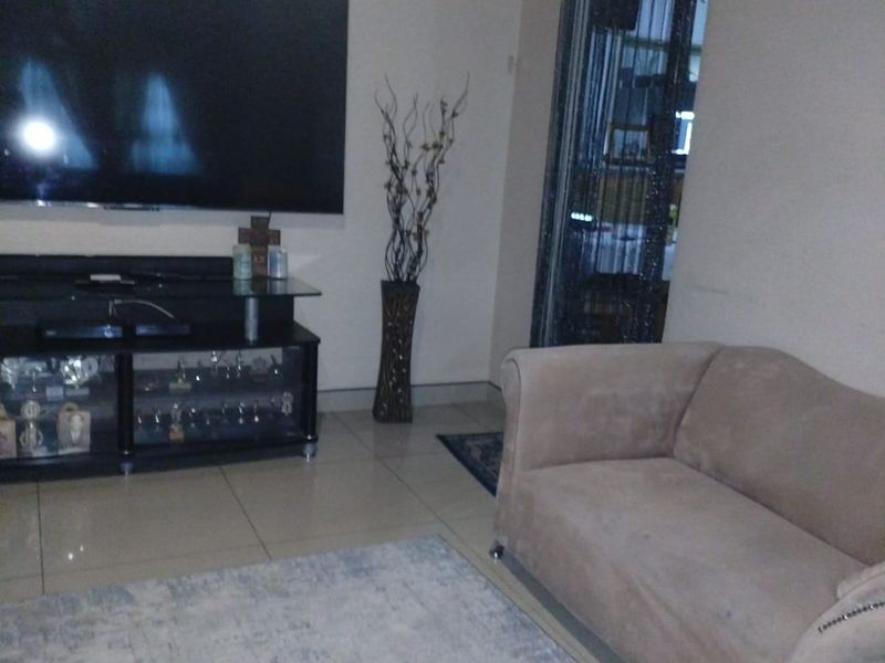 A living room area featuring tiled flooring and a neutral wall finish.