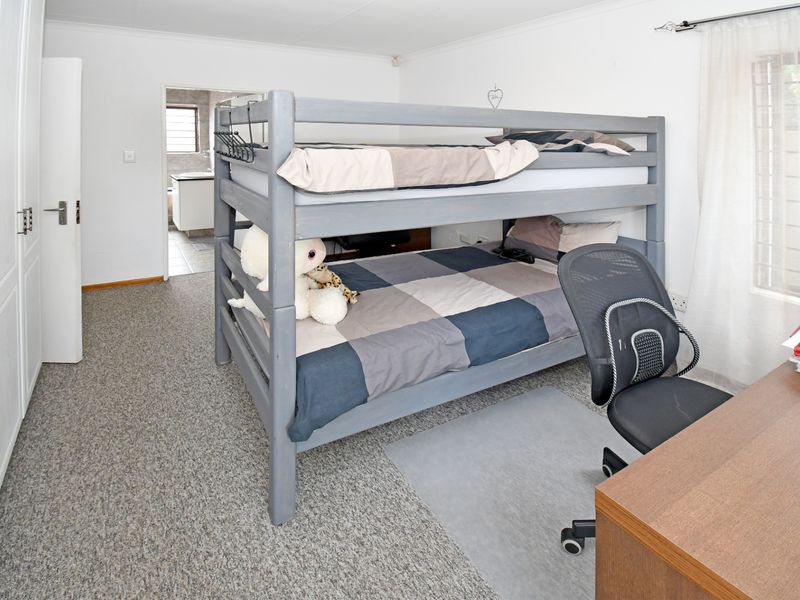 A functional bedroom featuring built-in cupboards, carpeted flooring, and direct access to an en-suite bathroom.
