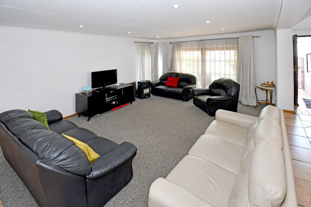 Spacious living room featuring neutral carpeting, recessed lighting, and large sliding glass doors providing access to the exterior.