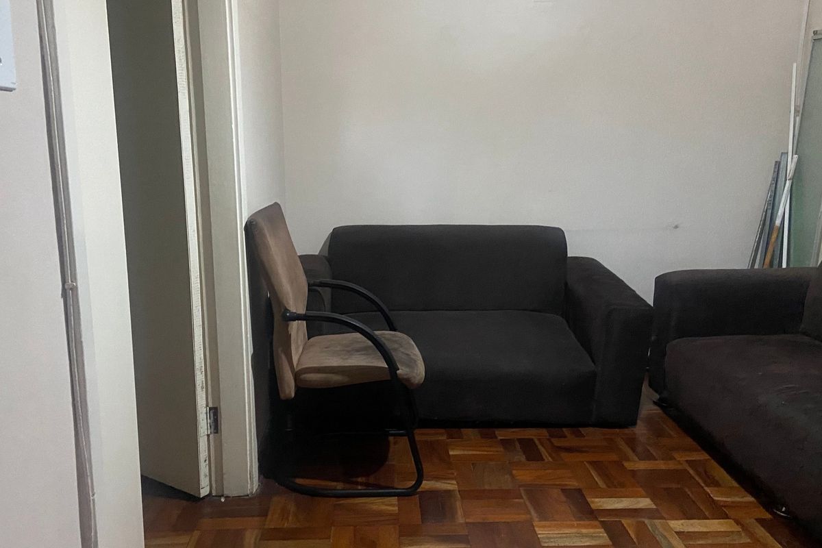 A living room area featuring traditional parquet flooring and neutral wall finishes, offering a blank canvas for potential interior updates and modernization.