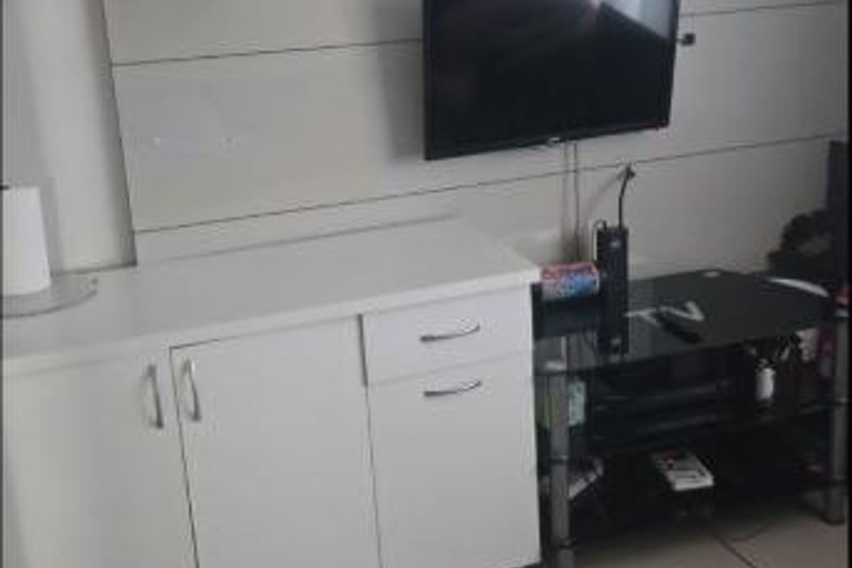 Living room area featuring a built-in wall panel unit with integrated cabinetry and ceramic floor tiles.