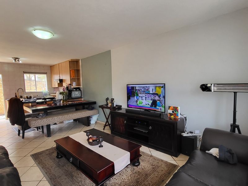 Open plan living and kitchen area featuring tiled flooring, functional cabinetry, and a connected layout suitable for modern living.