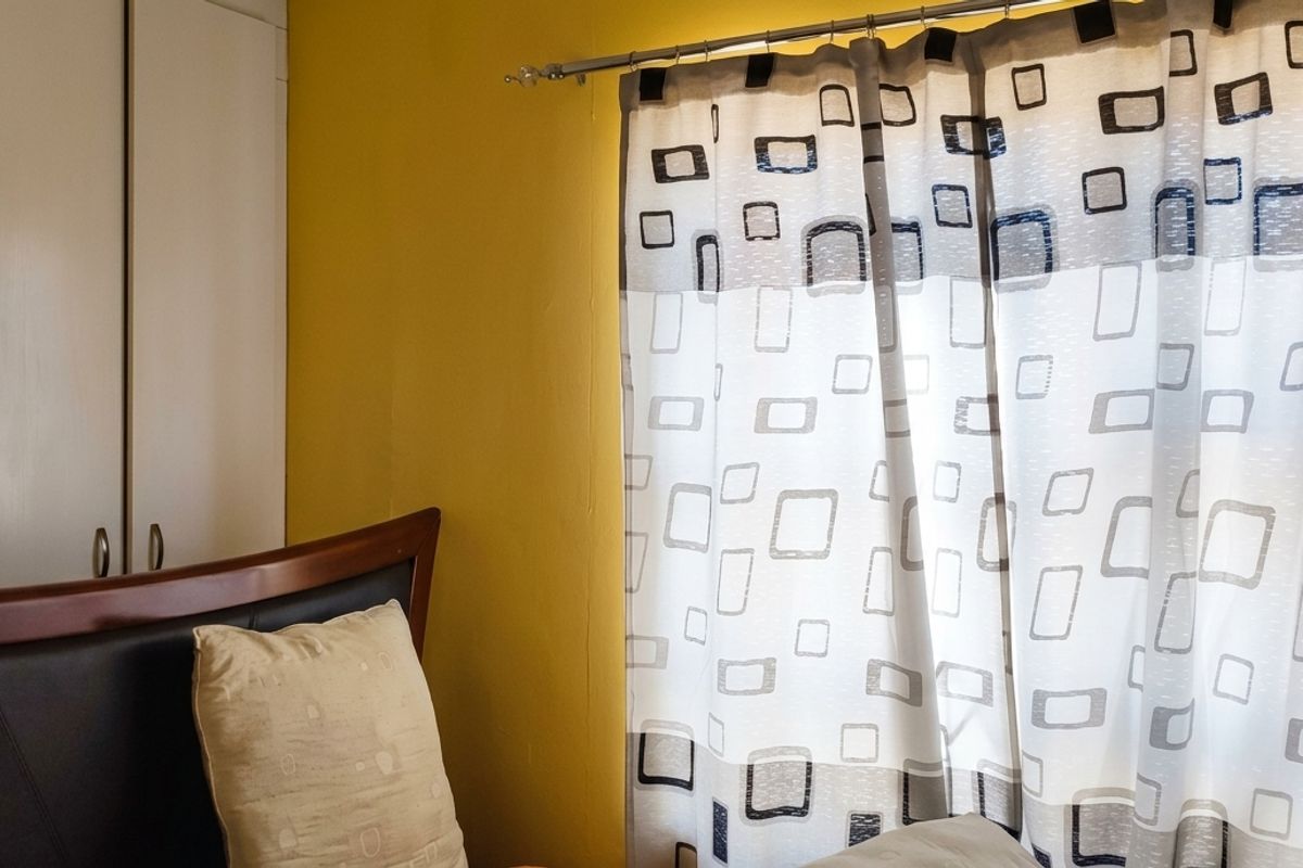 A bedroom featuring yellow walls and a built-in wardrobe with white doors.