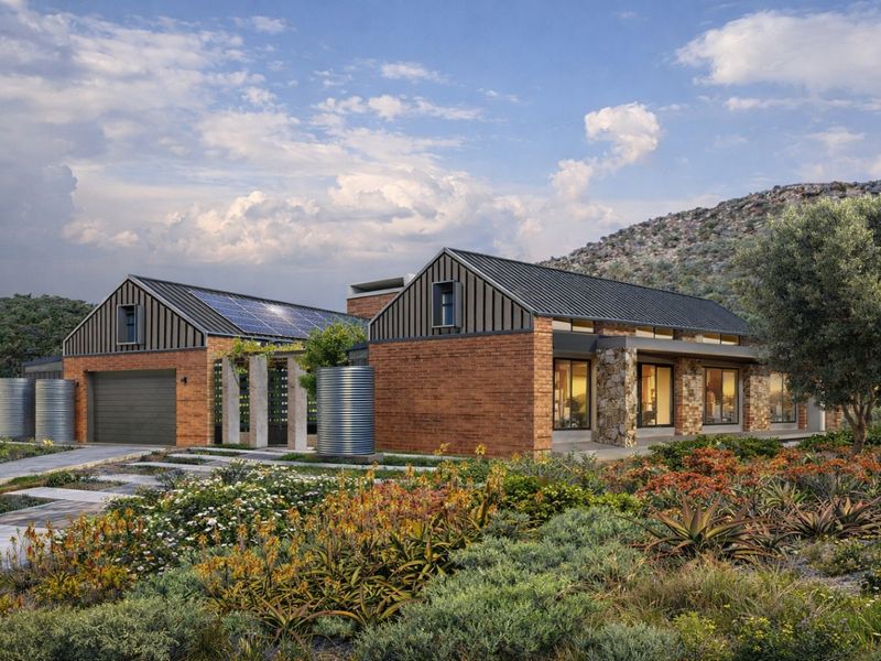 A modern architectural rendering of a brick and stone house featuring solar panels, metal roofing, and integrated water storage tanks in a landscaped setting.