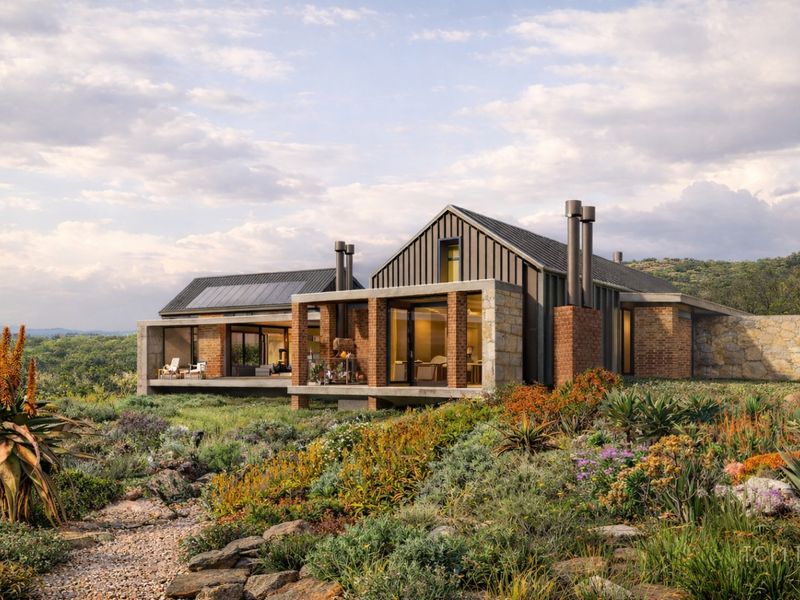 Modern architectural home featuring brick and stone construction, metal roofing with solar panels, and expansive covered patios overlooking a landscaped garden.