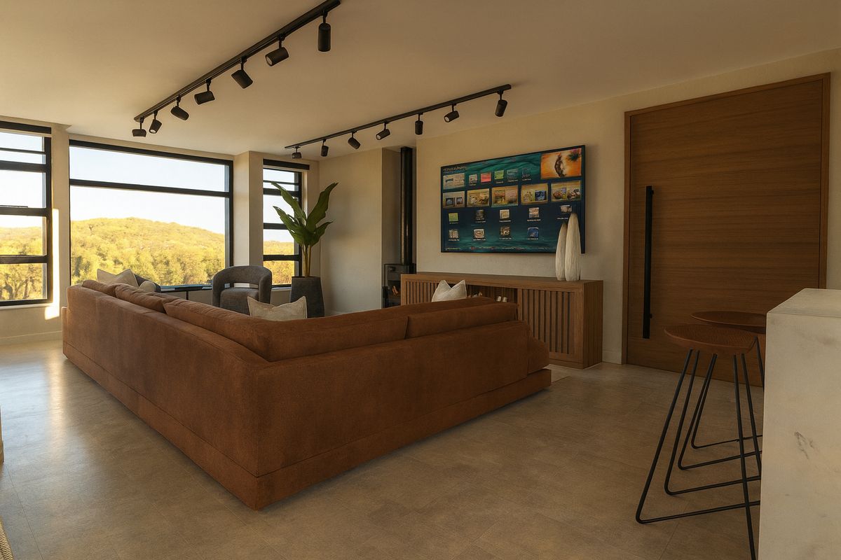 Modern open-plan living area featuring track lighting, large windows with scenic views, tiled floors, and a built-in fireplace.