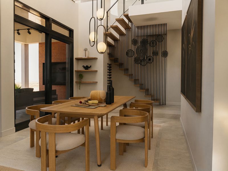 Modern dining area featuring a striking floating timber staircase, sleek metal balustrades, and large sliding glass doors opening to an outdoor space.