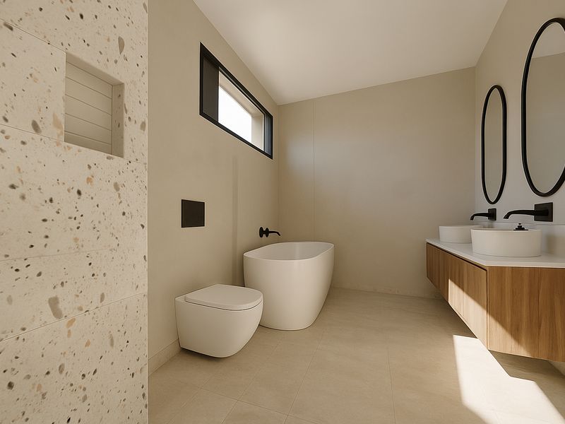 Modern, high-end bathroom featuring a freestanding tub, wall-hung toilet, double vanity with vessel sinks, and stylish terrazzo tile accents.
