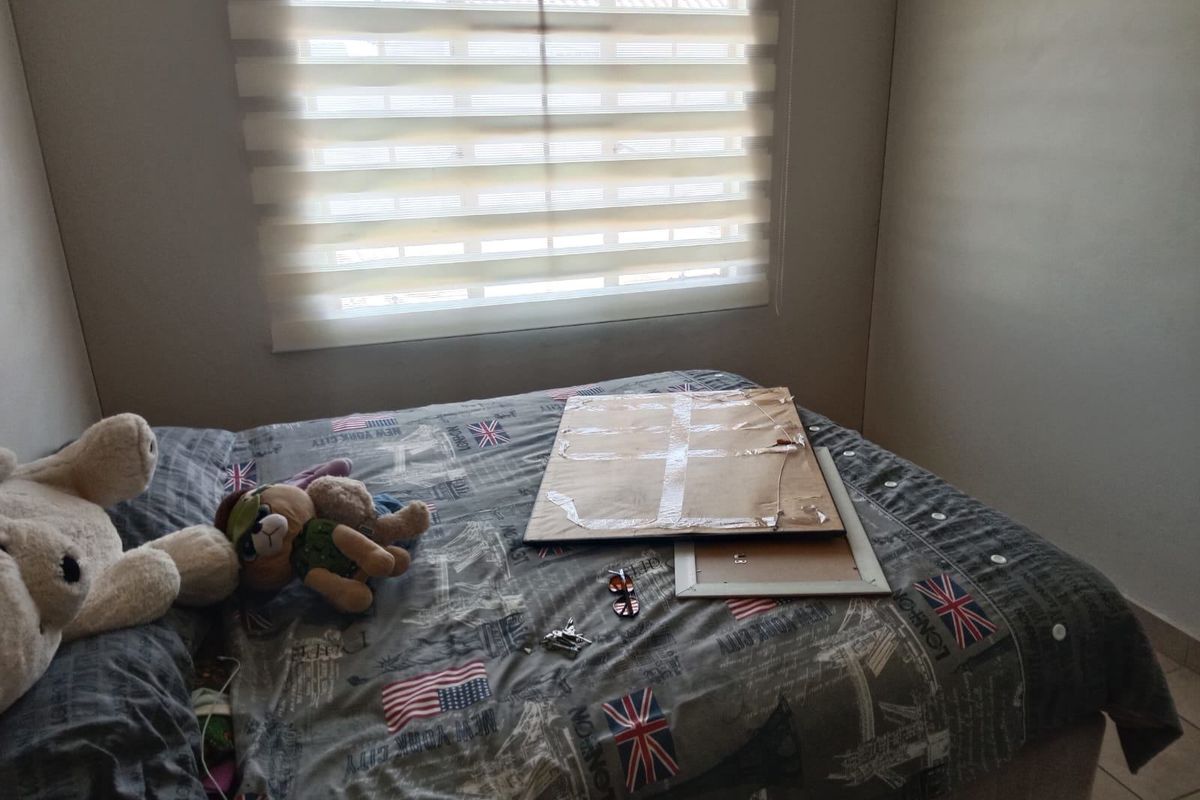 A bedroom featuring tiled flooring and modern roller blinds, providing a neutral base for interior design updates.