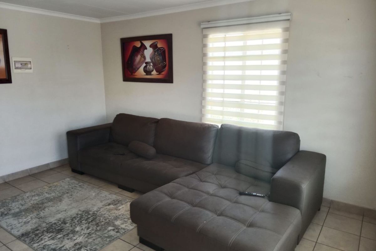 A living room featuring tiled flooring and modern roller blinds, providing a neutral base for interior design.