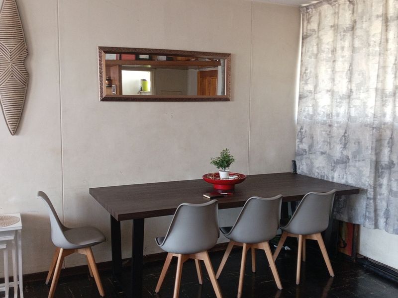 A dining area featuring dark flooring and neutral wall finishes, suitable for a modern update to enhance the space's overall appeal.