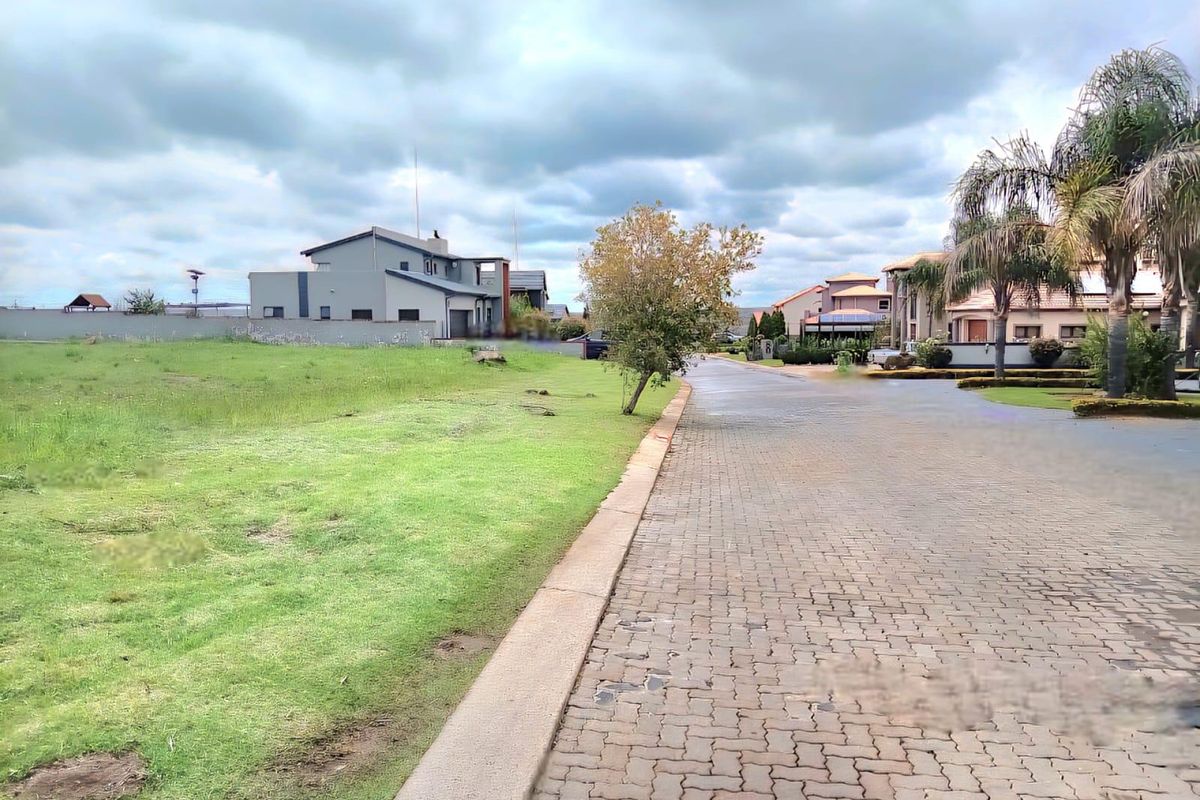 A view of a paved residential street with a grass verge and established neighborhood surroundings.
