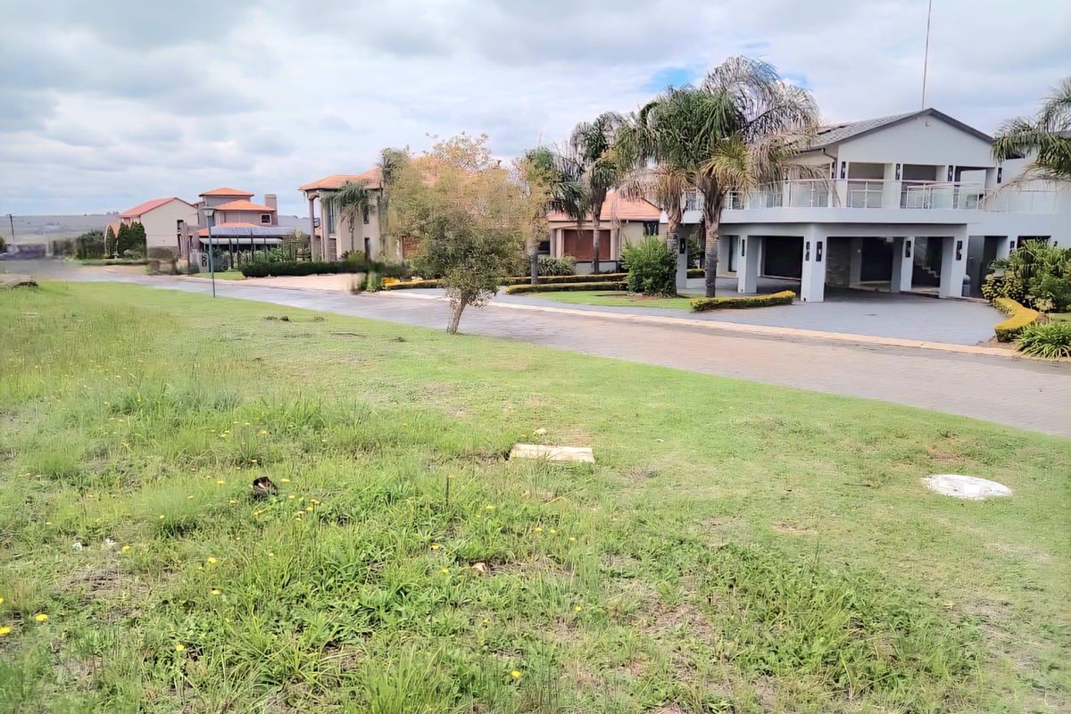 A view of a residential street in a well-maintained estate, featuring paved roads and established landscaping.