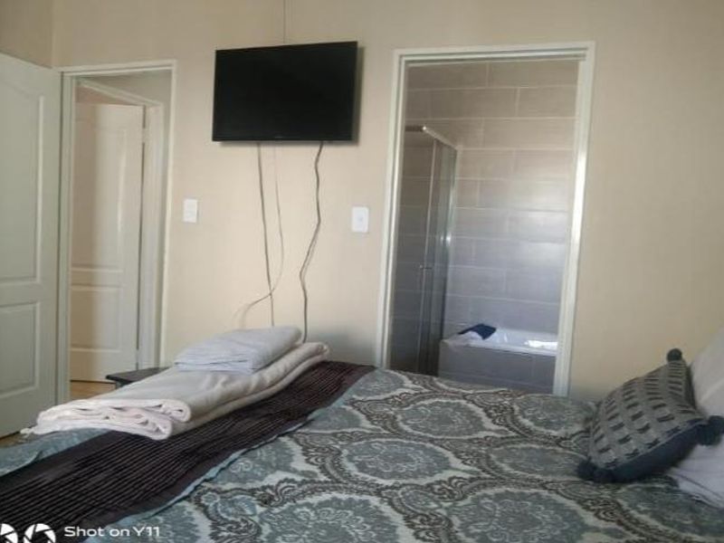 Bedroom featuring an en-suite bathroom with tiled walls, a shower, and a bathtub, providing convenient private facilities.