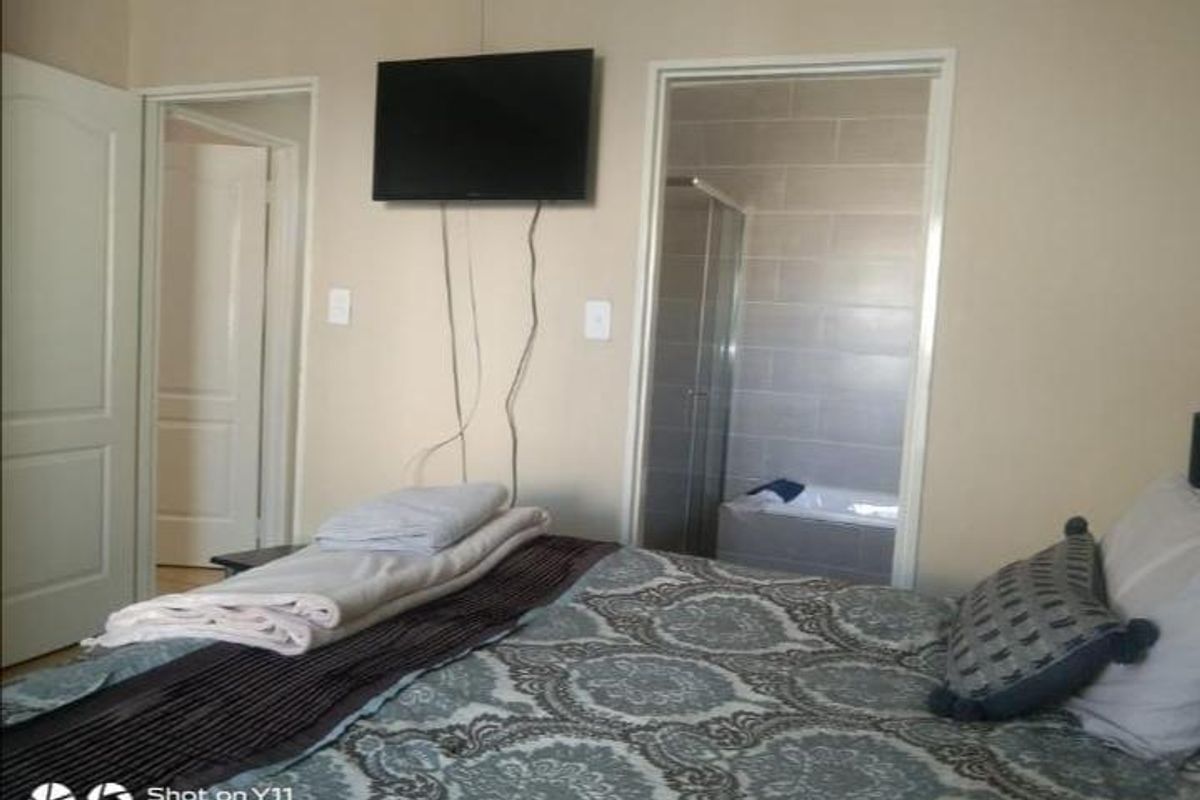 Bedroom featuring an en-suite bathroom with tiled walls, a shower, and a bathtub, providing convenient private facilities.