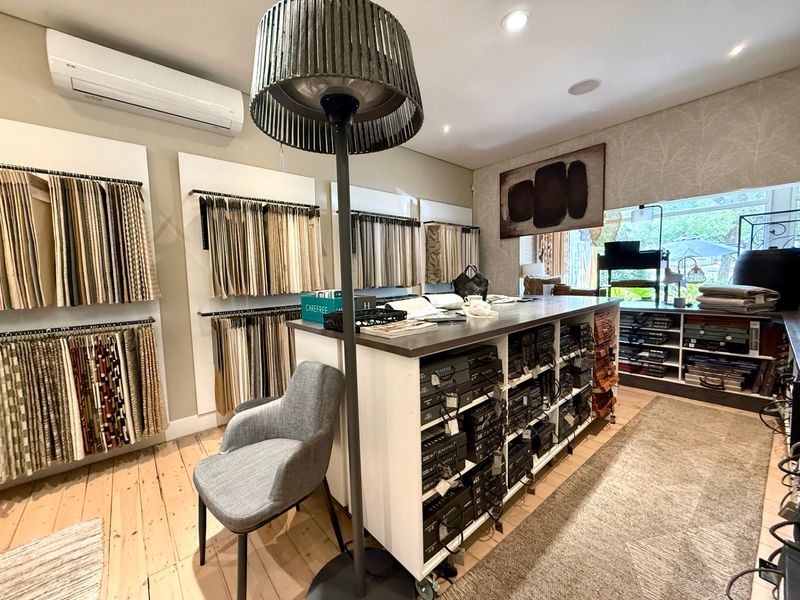 A well-organized commercial or studio utility space featuring extensive built-in fabric sample displays, recessed lighting, and wall-mounted climate control.