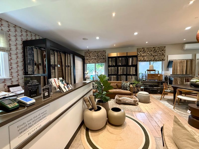 A well-maintained commercial showroom space featuring timber flooring, recessed lighting, and integrated air conditioning, currently utilized for fabric and textile displays.