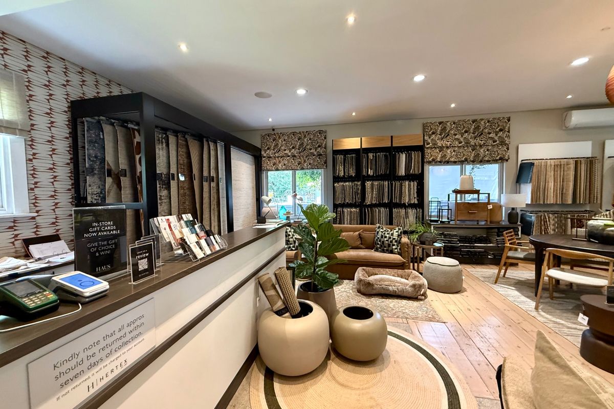 A well-maintained commercial showroom space featuring timber flooring, recessed lighting, and integrated air conditioning, currently utilized for fabric and textile displays.