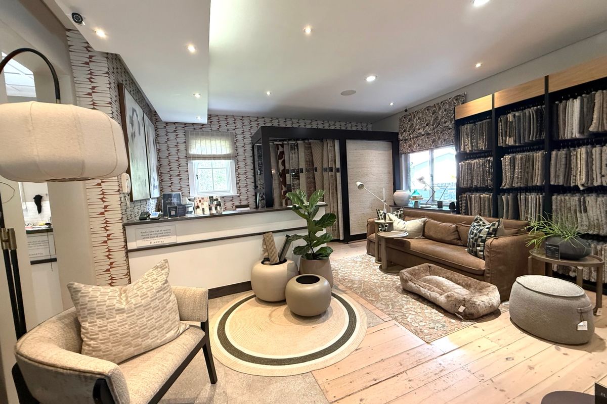 A well-appointed interior space featuring timber flooring, recessed lighting, and built-in display shelving, currently utilized as a professional showroom or reception area.
