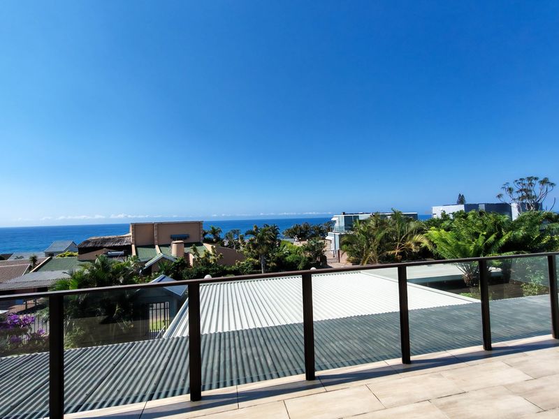 Elevated balcony view overlooking the surrounding coastal neighborhood and ocean horizon.