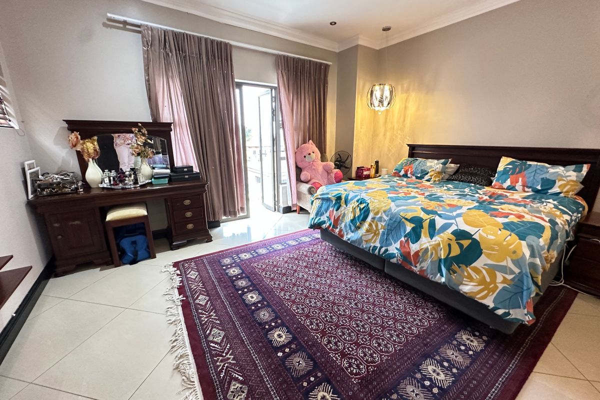 Spacious bedroom featuring tiled flooring, recessed lighting, and direct access to an outdoor area through a sliding glass door.