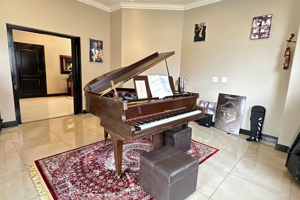 A spacious living area featuring polished porcelain floor tiles, coved cornicing, and recessed lighting, providing a neutral and well-maintained foundation for the home.